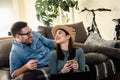 Smiling young Caucasian couple shopping online at home using a laptop with a credit card Royalty Free Stock Photo