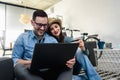 Smiling young Caucasian couple shopping online at home using a laptop with a credit card Royalty Free Stock Photo