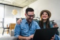 Smiling young Caucasian couple shopping online at home using a laptop with a credit card Royalty Free Stock Photo
