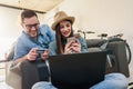 Smiling young Caucasian couple shopping online at home using a laptop with a credit card Royalty Free Stock Photo