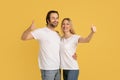 Smiling young caucasian family in white t-shirts make thumbs up gesture, approving great offer and ad Royalty Free Stock Photo