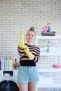 Smiling young Caucasian female Wearing yellow rubber gloves for clean of housework in loundry room. Lifestyle of Family on Holiday Royalty Free Stock Photo