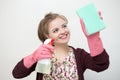 Smiling young caucasian girl woman with rubber gloves, sponge and sprayer, cleaning the house
