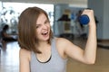 Smiling young caucasian woman girl doing workout with light dumbbells at the gym, lifting weights Royalty Free Stock Photo