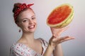 Smiling young Caucasian woman girl holding advertising a watermelon cut in half.Vegetarian lifestyle or summer vibes concept