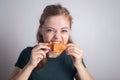 Smiling young Caucasian woman girl holding eating fried chicken drumstick