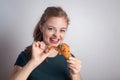 Smiling young Caucasian woman girl holding eating fried chicken drumstick