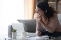 Smiling young woman in headset make notes studying on laptop Royalty Free Stock Photo