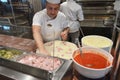 Smiling young chef in a white uniform serves traditional Italian pizza on a cruise liner MSC Meraviglia. 10 October 2018 Royalty Free Stock Photo