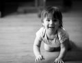 A smiling young child crawling on the floor