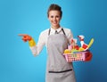 Cleaning woman with basket with cleansers and brushes pointing