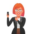 Smiling young confident woman in glasses points to a smartphone in her hand. Beautiful happy girl in a business suit with red hair Royalty Free Stock Photo