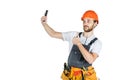 Smiling young construction worker showing a sign and taking a pi Royalty Free Stock Photo