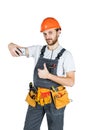 Smiling young construction worker showing a sign and taking a pi Royalty Free Stock Photo