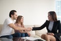 Smiling young couple clients shaking hands with agent, lawyer, m Royalty Free Stock Photo