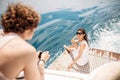 Smiling young couple holding glasses with beverage while travelling on yacht Royalty Free Stock Photo