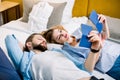 Smiling young couple looking at their passports for travel, while lying on the bed in hotel or appartment room Royalty Free Stock Photo