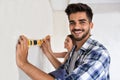 Smiling young couple measuring wall with level tool, renovation Royalty Free Stock Photo