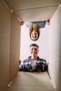 Smiling young couple opening a carton box and looking inside, relocation and unpacking concept Royalty Free Stock Photo