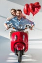 smiling young couple with red heart shaped balloons Royalty Free Stock Photo