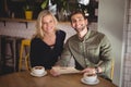 Smiling young couple sitting with coffee cups and menu at table Royalty Free Stock Photo