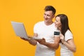 Smiling young couple two friends guy girl in white t-shirts posing isolated on yellow orange wall background. People Royalty Free Stock Photo