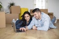 Smiling Young Couple Using Laptop After Moving To Their New Home Royalty Free Stock Photo