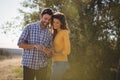 Smiling young couple using mobile phone at olive farm Royalty Free Stock Photo