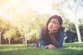 Charming smiling young hipster woman lying on green grass. Royalty Free Stock Photo