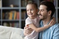 Smiling young dad and little daughter visualize at home