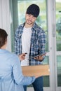 Smiling young delivery man holding cardboard box Royalty Free Stock Photo