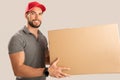 Smiling young delivery man holding and carrying a cardbox Royalty Free Stock Photo