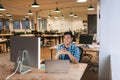 Smiling young designer working at his desk in an office Royalty Free Stock Photo