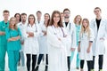 Smiling young doctor standing in front of a group of medical workers