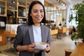 Smiling young Asian professional woman wearing suit holding coffee, portrait Royalty Free Stock Photo