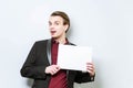 Smiling young european business man in red polo shirt and blazer holding blank A4 signboard. Business background with copy space Royalty Free Stock Photo