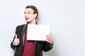 Smiling young european business man in red polo shirt and blazer holding blank A4 signboard and showing thumb up. Business Royalty Free Stock Photo