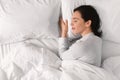 Smiling young european female sleeping on white bed, enjoying good morning, weekend or free time Royalty Free Stock Photo