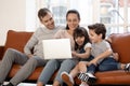 Smiling young family with kids relax at home with laptop Royalty Free Stock Photo