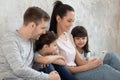 Happy young family with kids using cellphone watching video Royalty Free Stock Photo