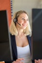 Business woman talking on microphone in office and working on computer Royalty Free Stock Photo