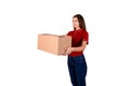 Smiling young female courier is giving a parcel box to a client isolated on white background Royalty Free Stock Photo