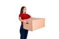 Smiling young female courier is giving a parcel box to a client isolated on white background Royalty Free Stock Photo