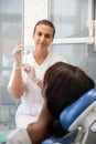 Smiling young female dentist putting on rubber gloves