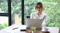 Young female designer working with computer laptop in modern office room. Royalty Free Stock Photo