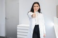 Smiling young female doctor looking at camera and showing thumbs up. Royalty Free Stock Photo