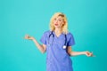 Smiling young female doctor or nurse wearing blue scrubs with arms out Royalty Free Stock Photo