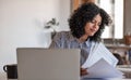 Smiling young female entrepreneur going over paperwork at home