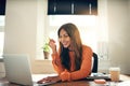 Smiling young female entrepreneur working on a laptop at home