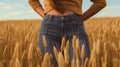 smiling young female farmer cowgirl standing in wheat cereal field. copy space